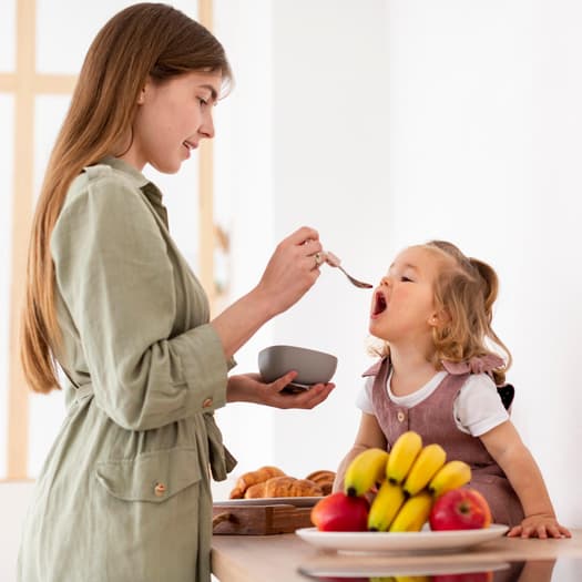 Mamma che dà da mangiare alla sua bambina